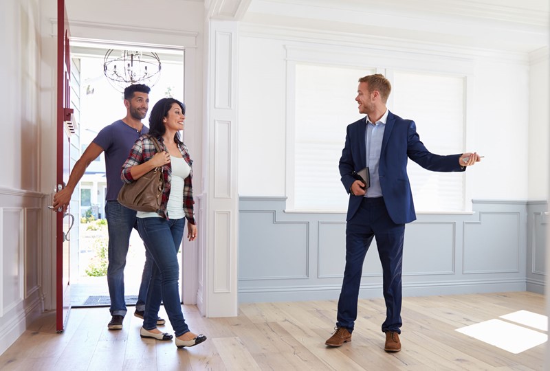 real estate agent showing a couple a home