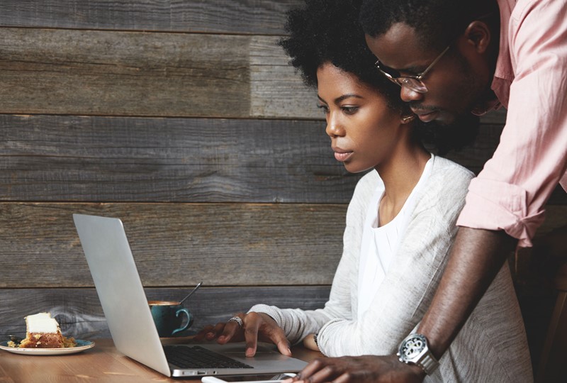 man and woman browsing on a laptop