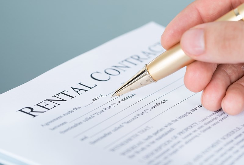 person signing a rental contract